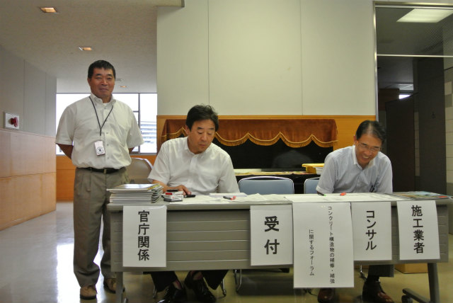 受付風景 鹿児島市の会員「㈱南防」の斎藤さん。極東興和㈱の長岡専務、そして、緒方所長 | 2013/07 熊本フォーラム | 一般社団法人コンクリートメンテナンス協会